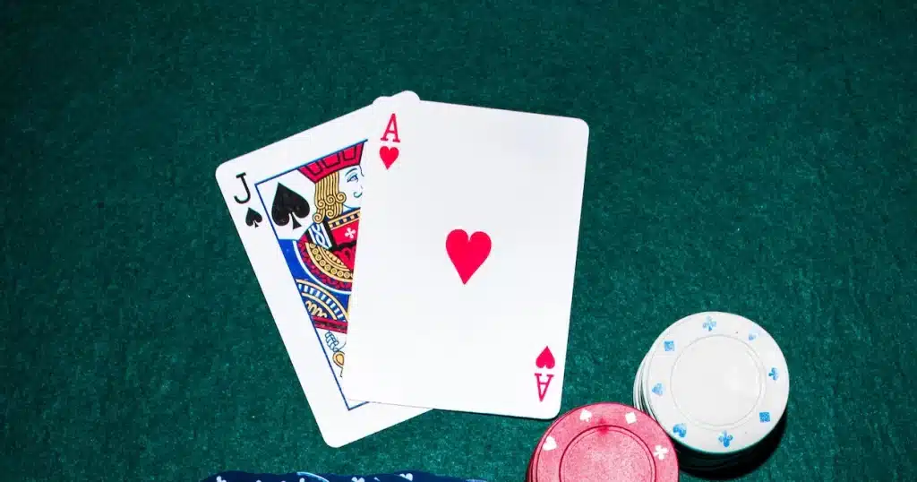 Ace of hearts and jack of spades on a blackjack table with chips