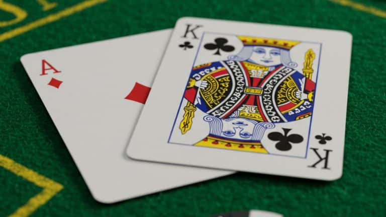 Ace of diamonds and King of clubs on a blackjack table