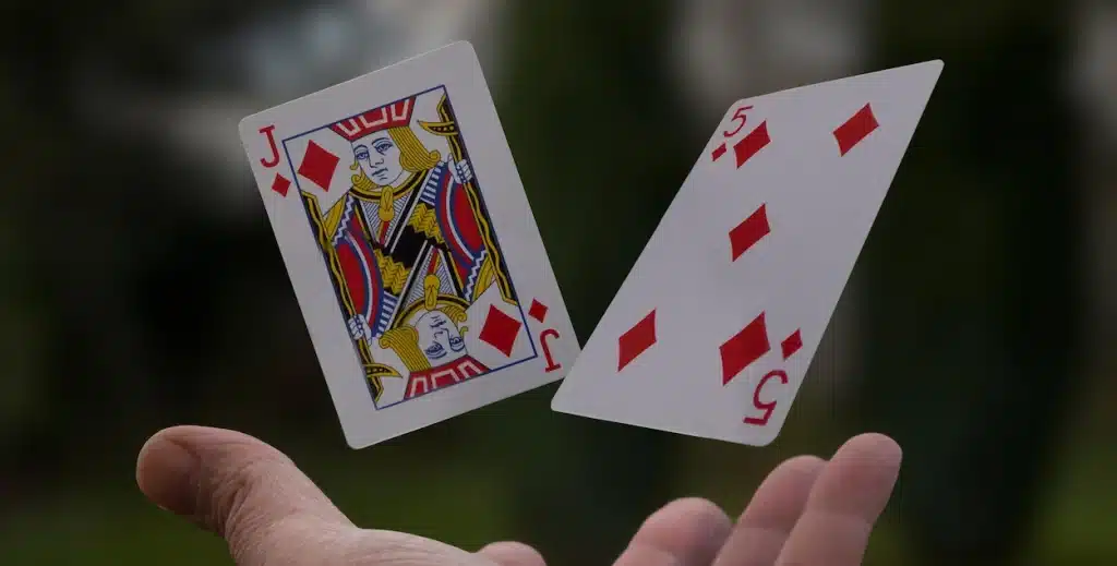 Jack and 5 of diamonds being thrown into the air.