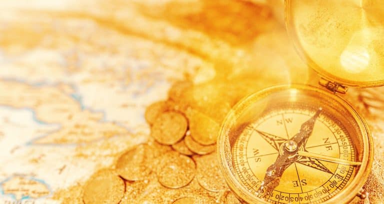 Gold coins and a gold compass on a treasure map